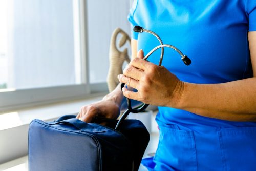 a woman in a blue scrub suit holding a stethoscope