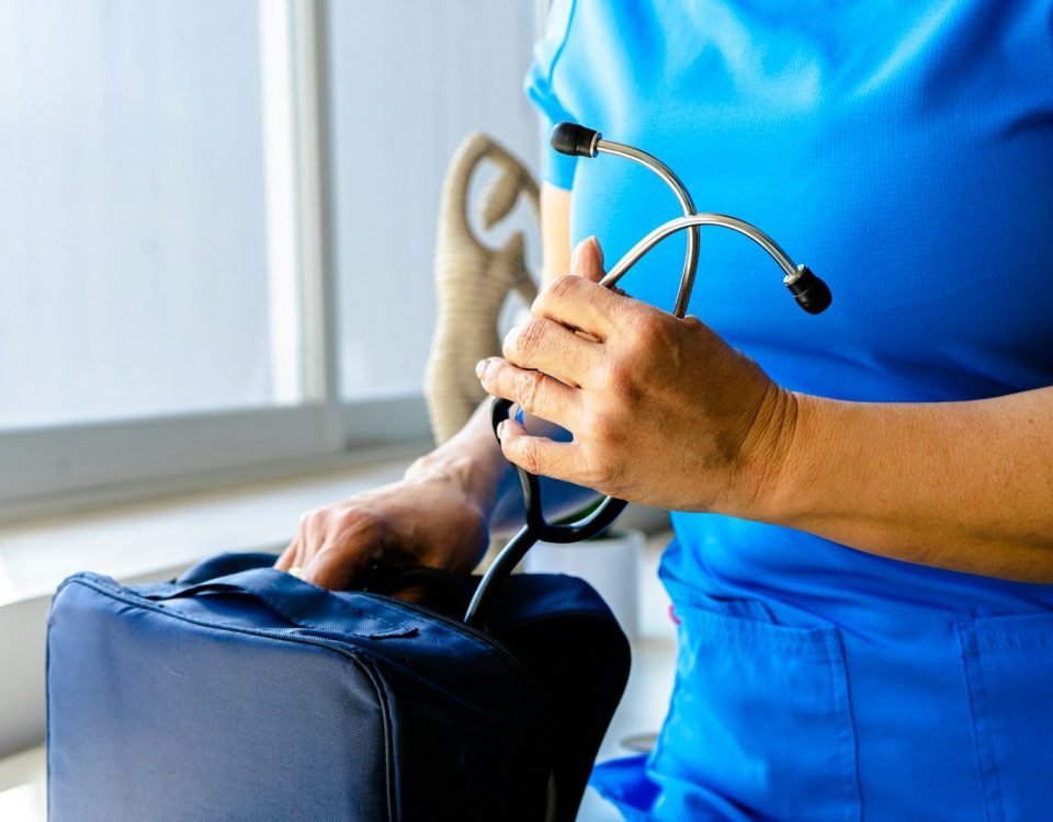 a woman in a blue scrub suit holding a stethoscope