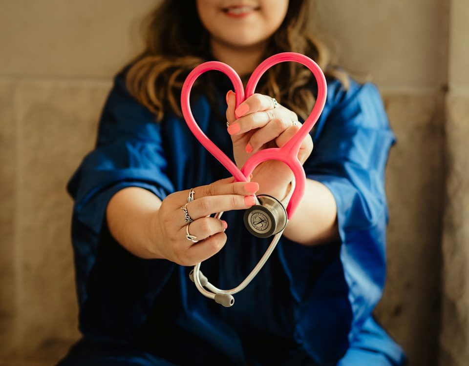 girl in blue jacket holding red and silver ring